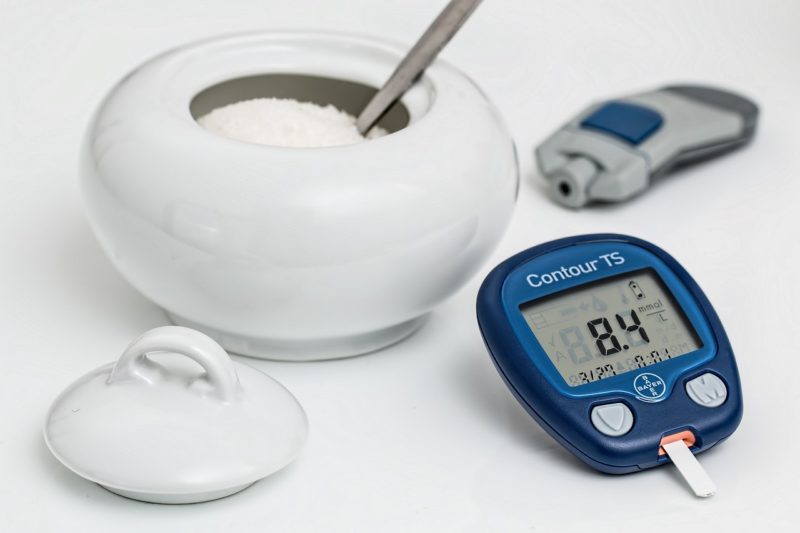 glukometr leżący na stole i cukier